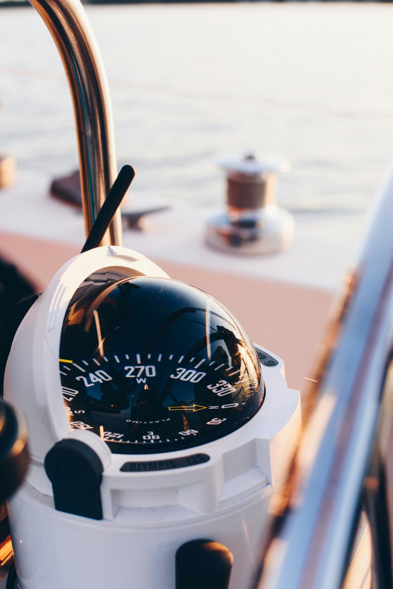 Close-up of a binnacle compass at the helm in warm evening light