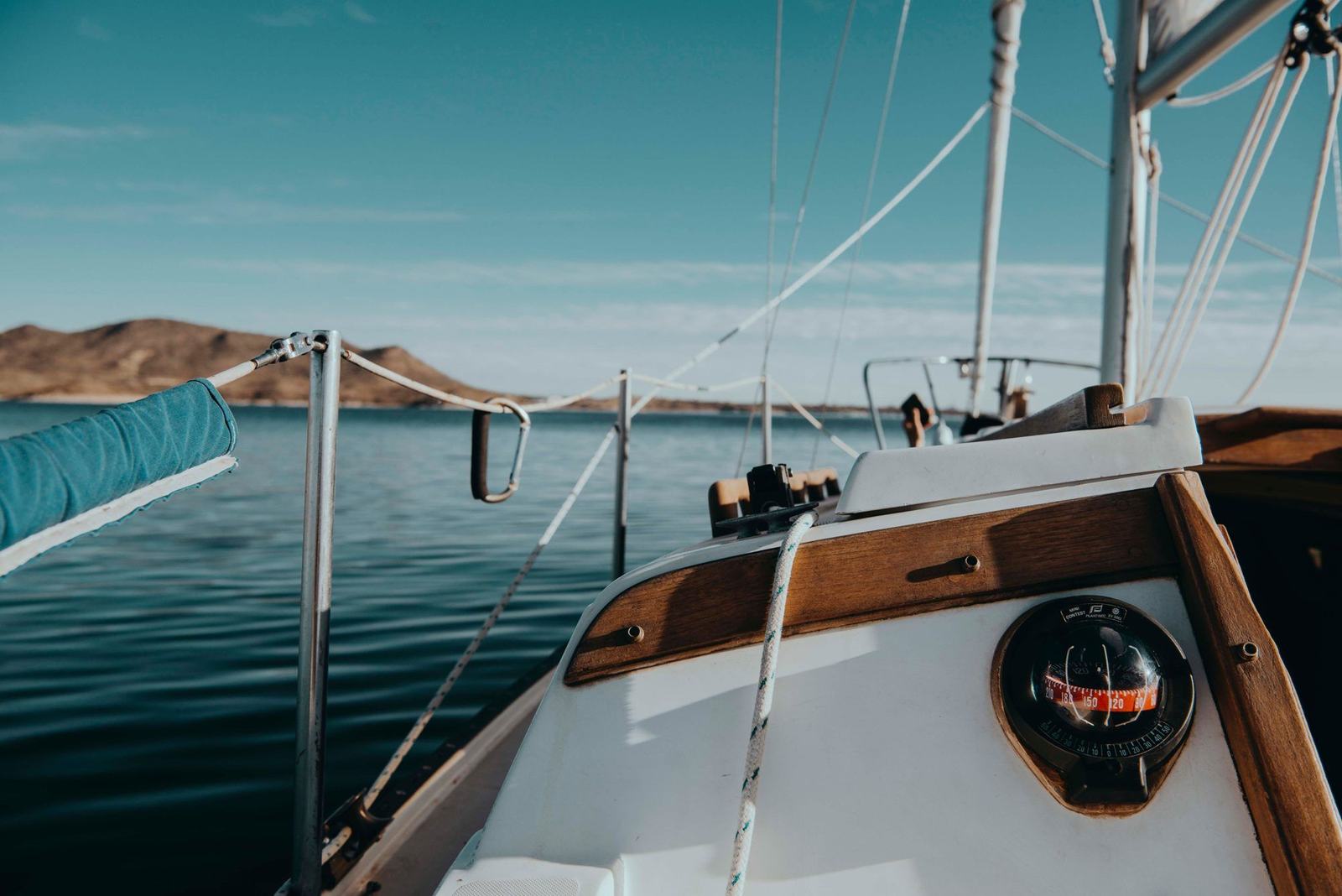 View forward from the cockpit of a sailboat, compass in the foreground