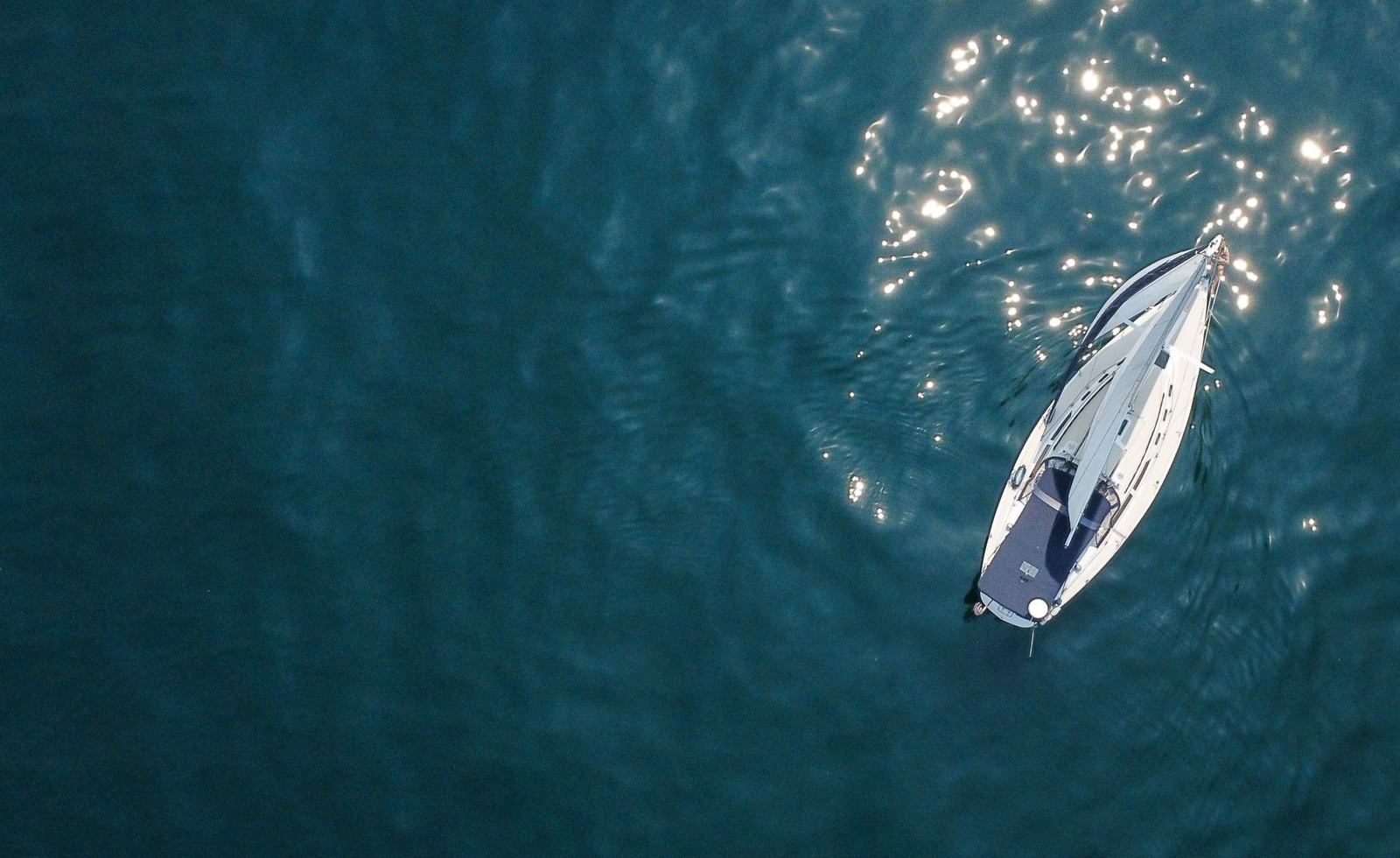 Sailboat seen from above on dark green water